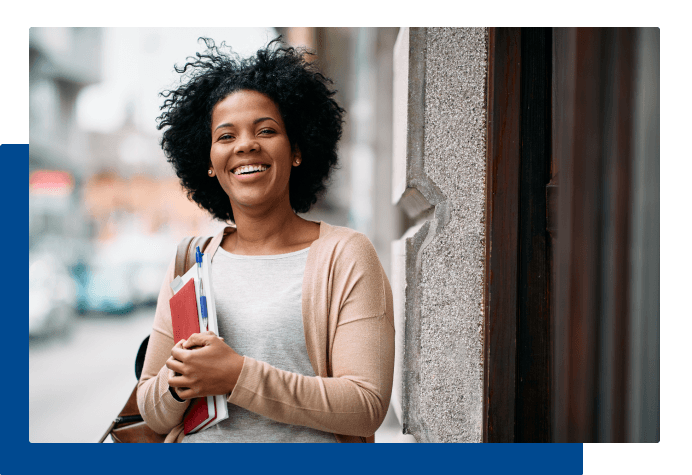 Smiling student holding books and backpack